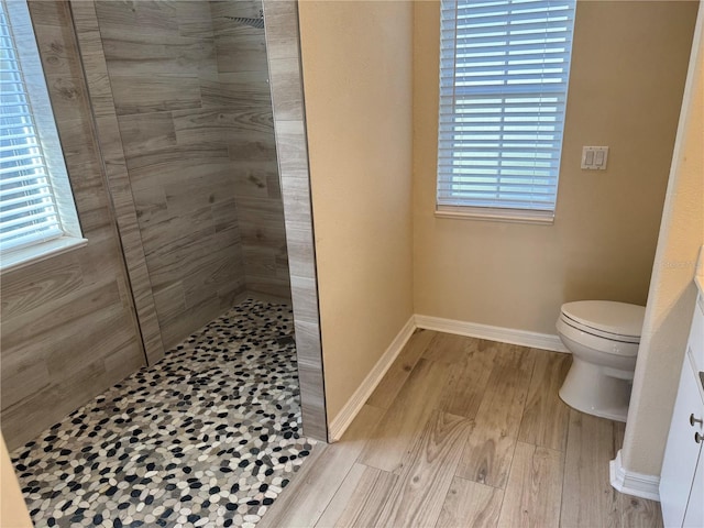 bathroom with hardwood / wood-style floors, toilet, and a wealth of natural light