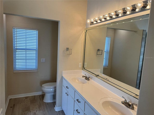 bathroom featuring wood-type flooring, vanity, and toilet