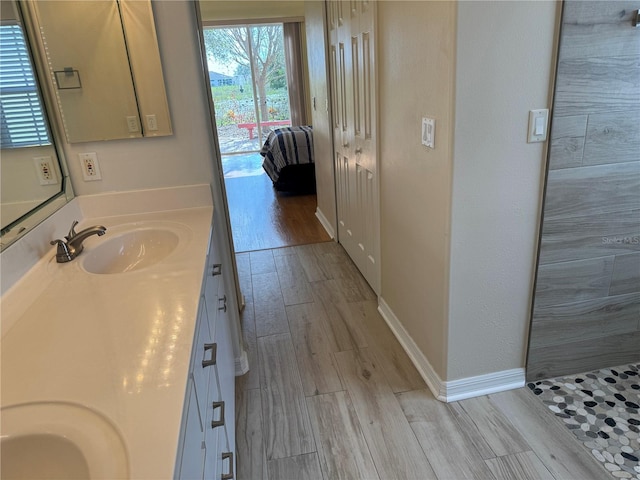 bathroom with walk in shower, vanity, and hardwood / wood-style flooring