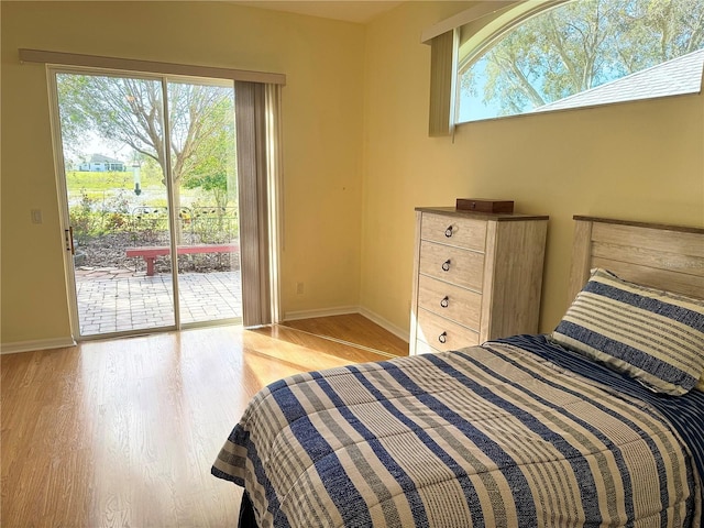 bedroom with access to exterior and light hardwood / wood-style floors