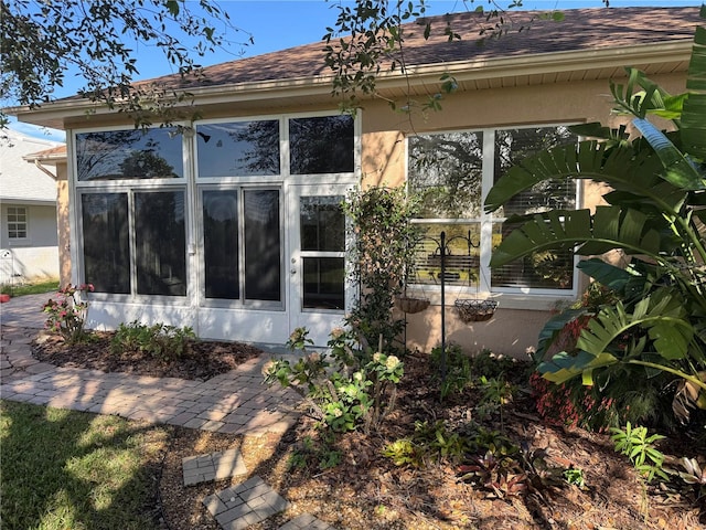 view of property exterior with a sunroom