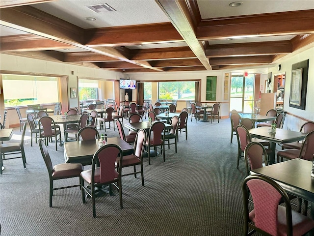 carpeted dining area with beam ceiling, a healthy amount of sunlight, and coffered ceiling