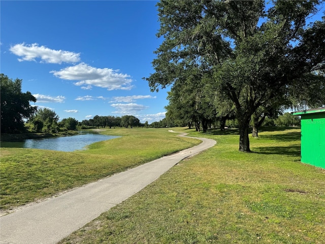 view of property's community featuring a lawn and a water view