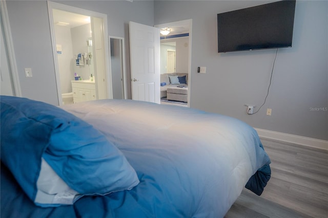 bedroom featuring hardwood / wood-style flooring and ensuite bath