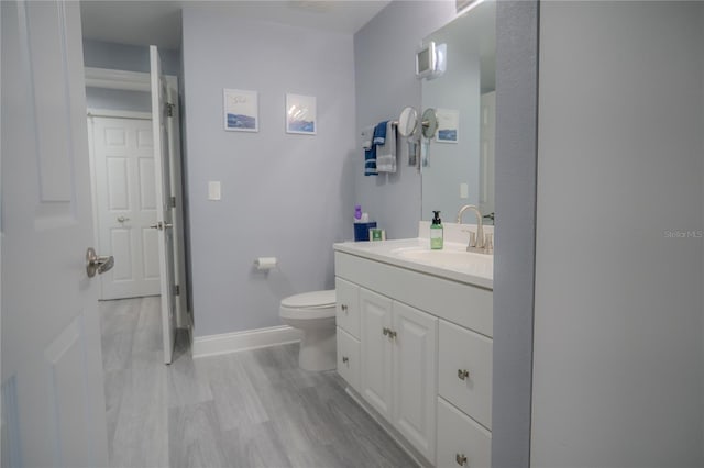 bathroom featuring vanity, toilet, and wood-type flooring