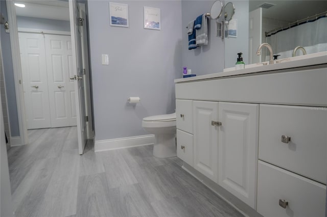 bathroom featuring vanity, toilet, and wood-type flooring