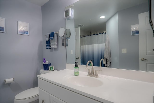 bathroom featuring a shower with curtain, vanity, and toilet