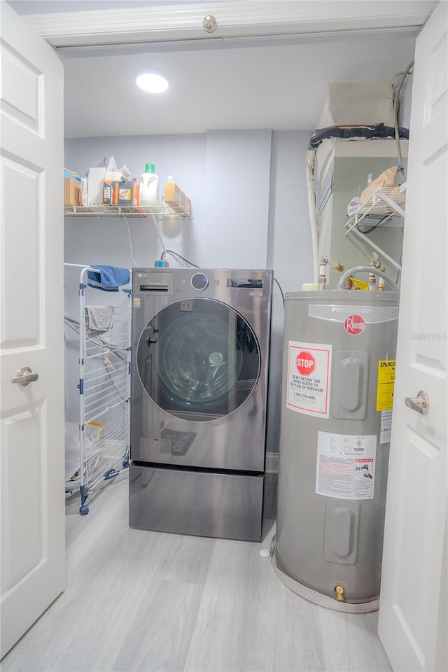 washroom featuring washer / clothes dryer, electric water heater, and wood-type flooring