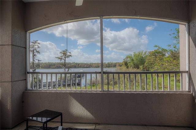 sunroom featuring a water view