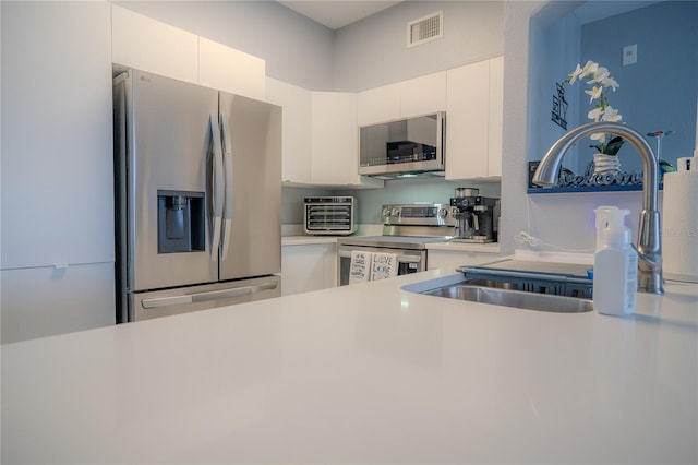 kitchen with sink, white cabinets, and appliances with stainless steel finishes