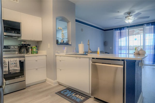 kitchen featuring appliances with stainless steel finishes, ceiling fan, sink, white cabinets, and light hardwood / wood-style floors