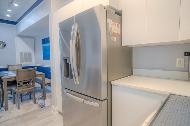 3406 Soho St Unit 102, Orlando, FL 32835 - kitchen with stainless steel fridge, light wood-type flooring, modern cabinets, white cabinetry, and light countertops