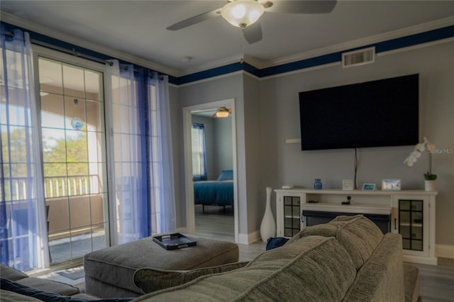 living room featuring hardwood / wood-style floors, ceiling fan, and ornamental molding