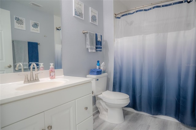 bathroom with vanity, hardwood / wood-style flooring, and toilet