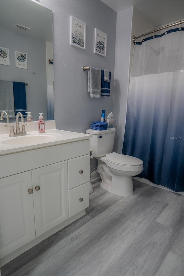 bathroom with vanity, toilet, and wood-type flooring