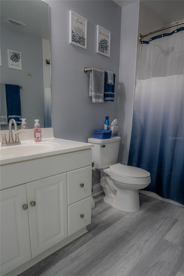 bathroom with hardwood / wood-style floors, vanity, and toilet