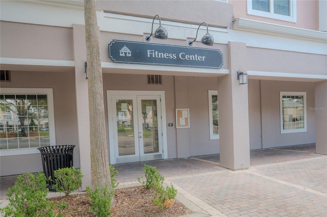 3406 Soho St Unit 102, Orlando, FL 32835 - view of exterior entry featuring french doors and stucco siding
