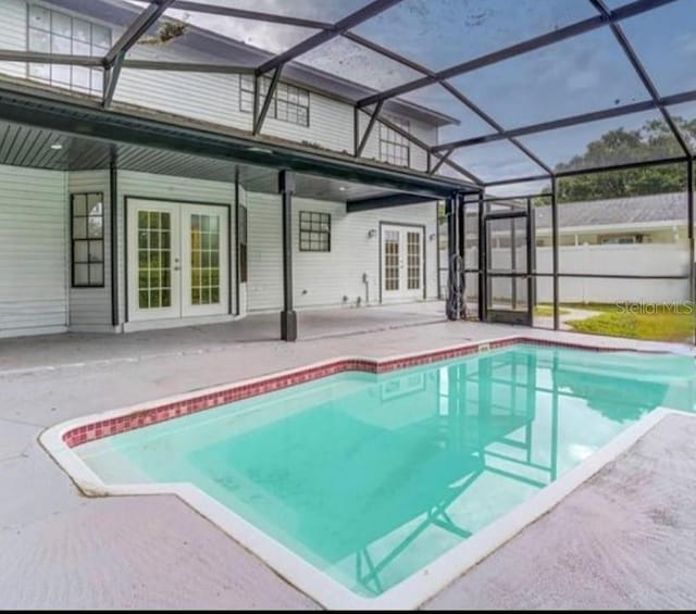 view of swimming pool with a lanai, french doors, and a patio