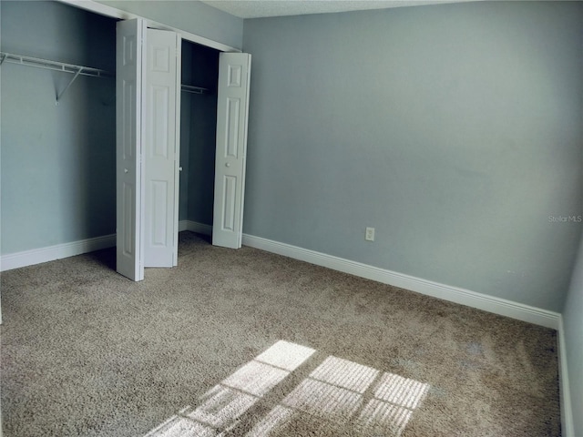 unfurnished bedroom featuring carpet and two closets