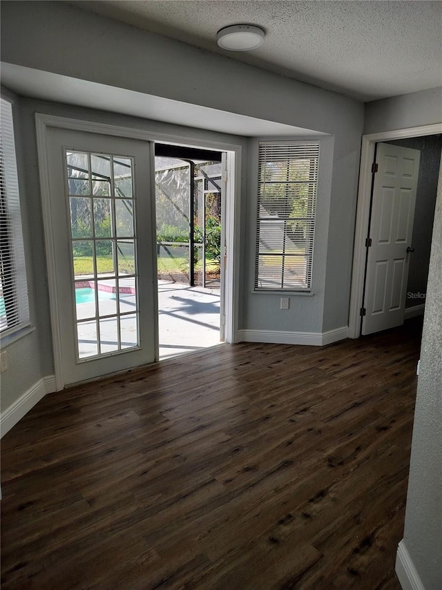 entryway featuring a textured ceiling and dark wood-type flooring