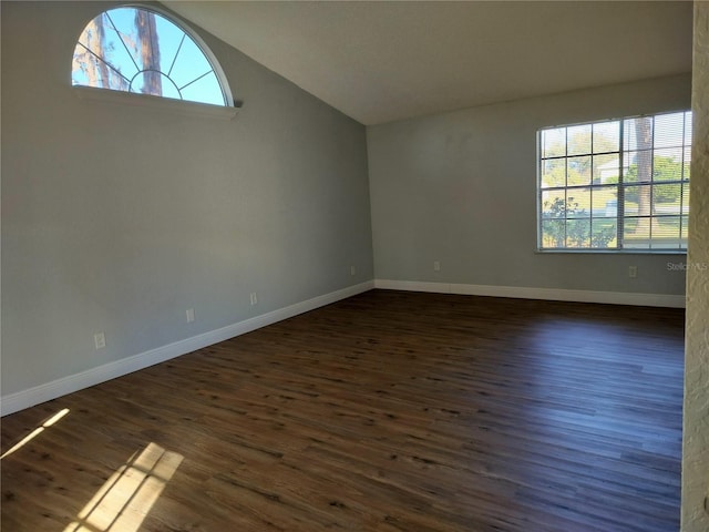 unfurnished room featuring dark wood-type flooring and vaulted ceiling