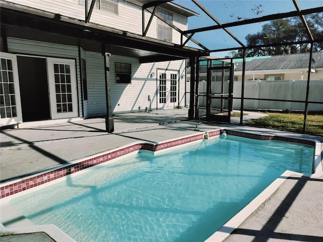 view of pool with glass enclosure and a patio area