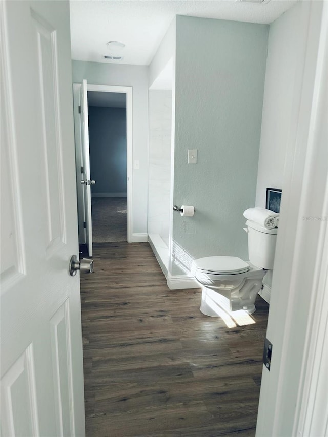 bathroom featuring wood-type flooring and toilet