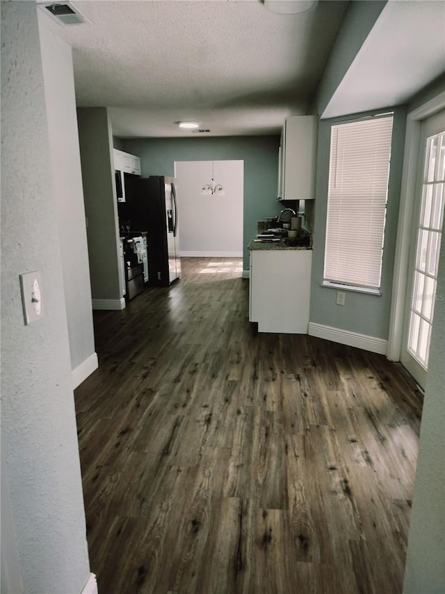 kitchen with dark hardwood / wood-style floors, white cabinetry, a healthy amount of sunlight, and a notable chandelier