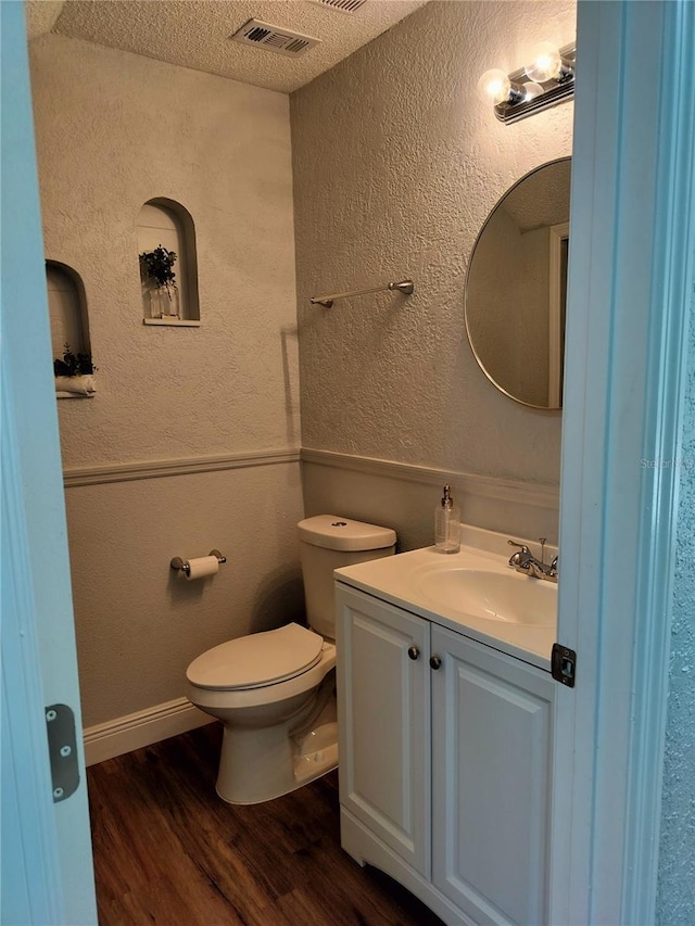 bathroom featuring hardwood / wood-style floors, vanity, a textured ceiling, and toilet