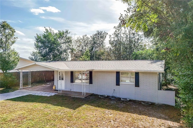 ranch-style house with a front lawn, a carport, and covered porch