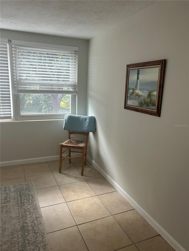 living area featuring a textured ceiling and light tile patterned floors