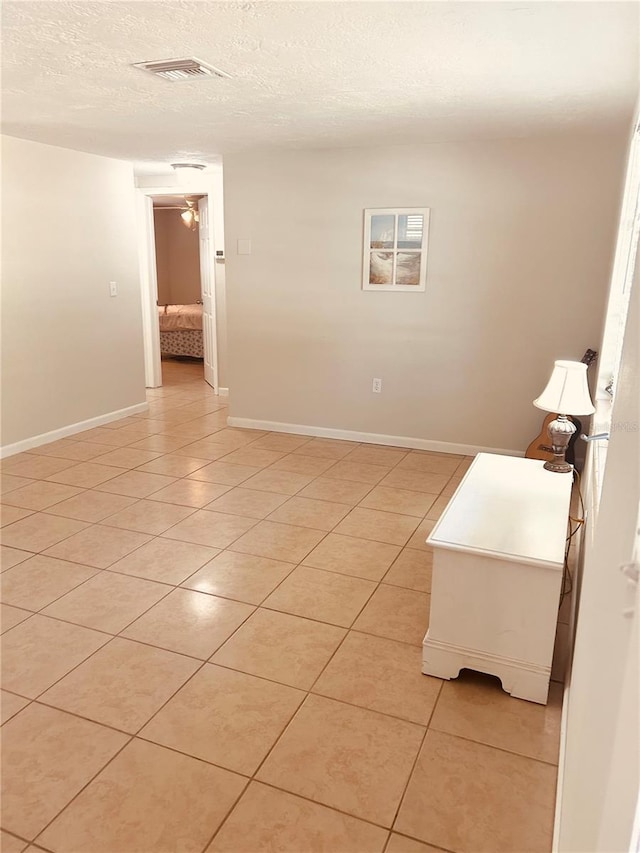 tiled empty room with a textured ceiling