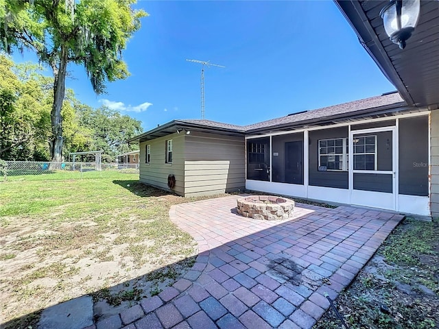 rear view of property with a sunroom, a yard, and a patio