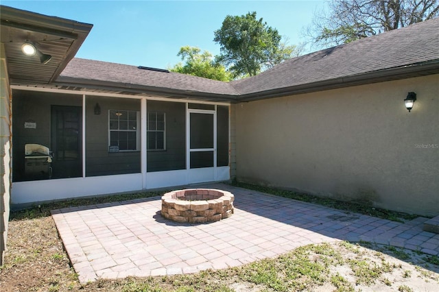 view of patio with a fire pit and a sunroom