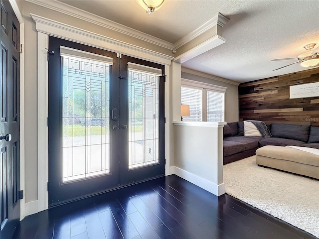 doorway to outside featuring ceiling fan, french doors, dark hardwood / wood-style flooring, crown molding, and a textured ceiling