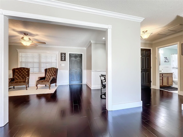 living area with a textured ceiling, dark hardwood / wood-style flooring, ceiling fan, and ornamental molding