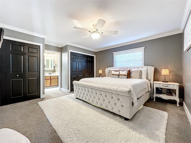 carpeted bedroom featuring a closet, ensuite bathroom, ceiling fan, and crown molding