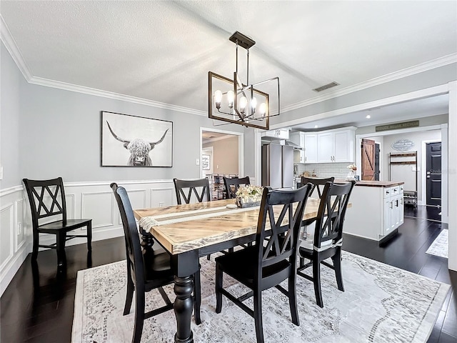 dining area with a chandelier, a textured ceiling, dark hardwood / wood-style floors, and ornamental molding