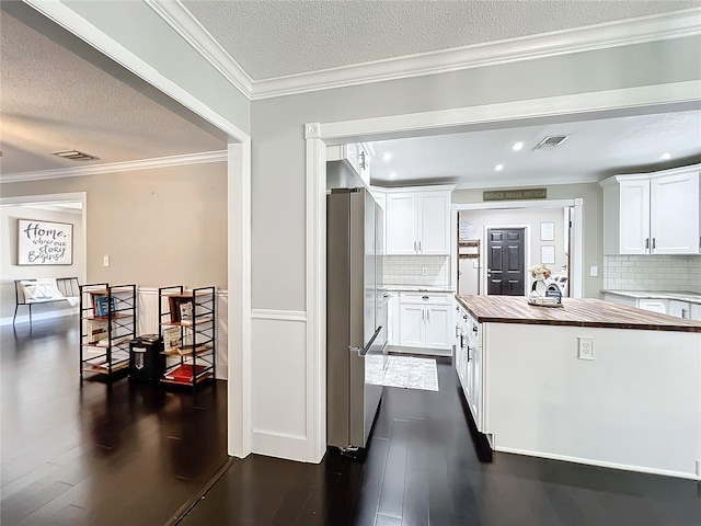 kitchen with white cabinetry, stainless steel fridge, dark hardwood / wood-style floors, and wood counters