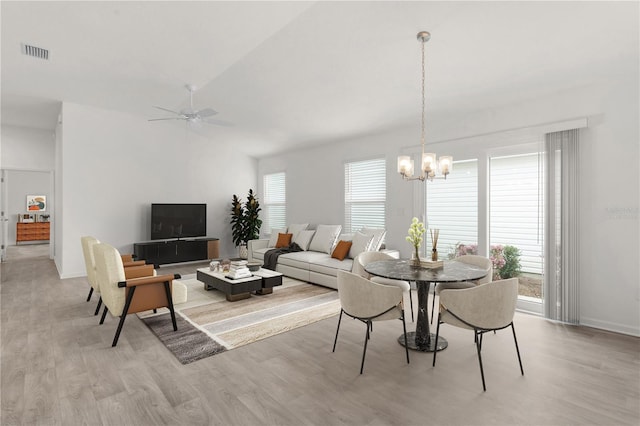 dining space featuring ceiling fan with notable chandelier and light wood-type flooring