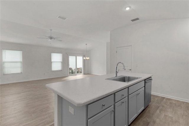 kitchen with dishwasher, lofted ceiling, a kitchen island with sink, sink, and light hardwood / wood-style flooring