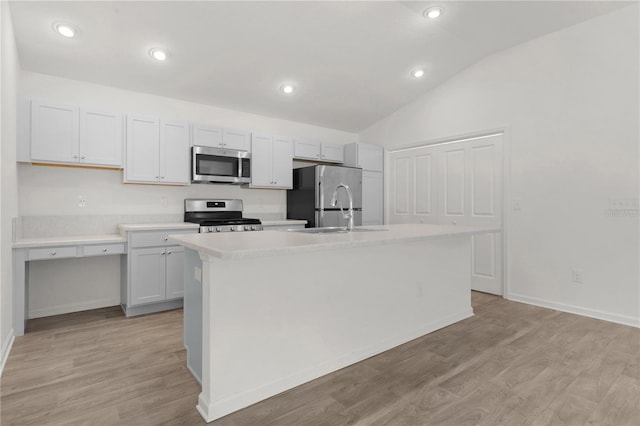 kitchen with white cabinetry, a center island with sink, lofted ceiling, and appliances with stainless steel finishes