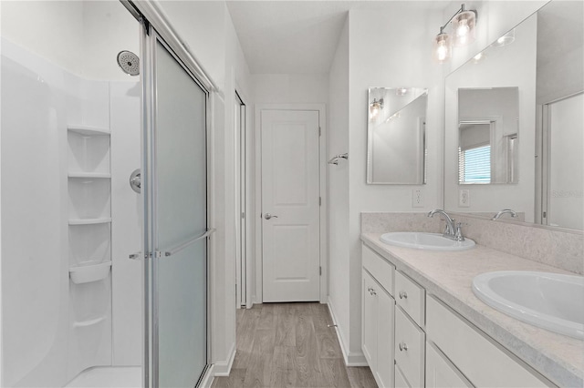 bathroom featuring a shower with door, vanity, and hardwood / wood-style flooring