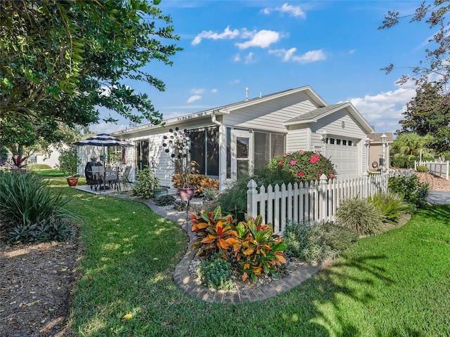 rear view of property featuring a lawn, a patio, and a garage