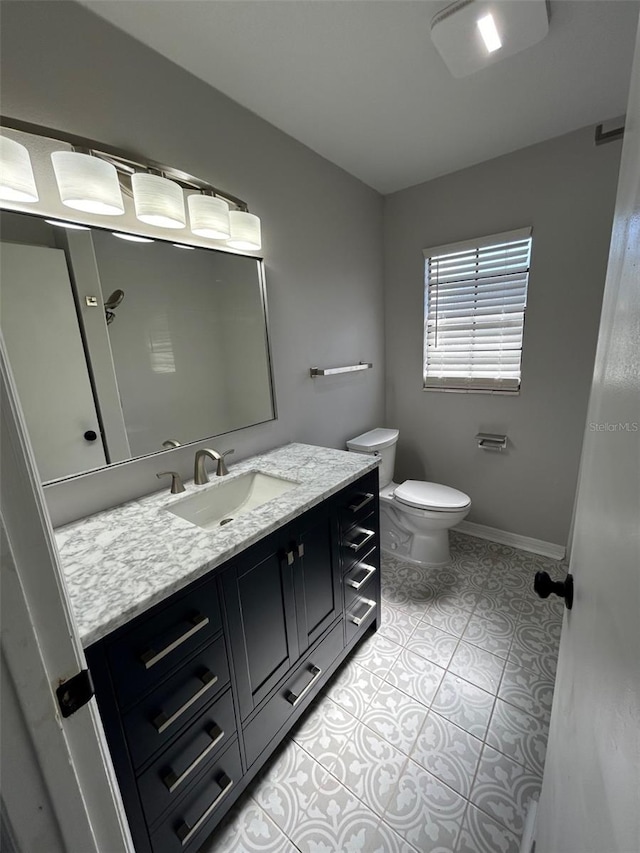 bathroom featuring tile patterned flooring, vanity, and toilet