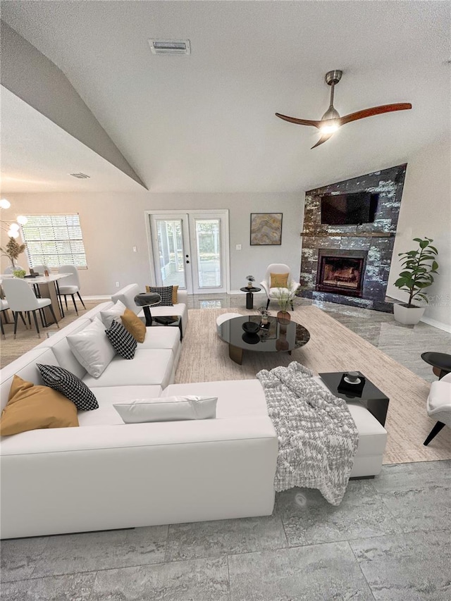 living room featuring a textured ceiling, a wealth of natural light, and lofted ceiling