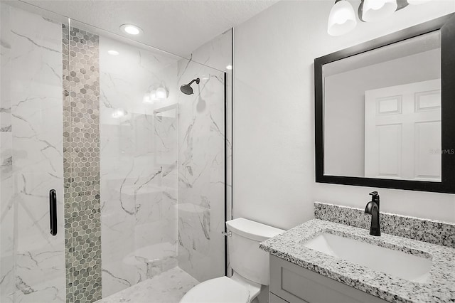 bathroom with vanity, toilet, and a shower with door