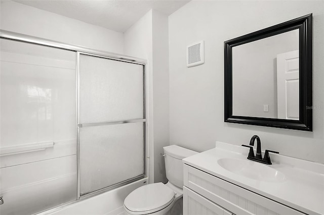 full bathroom with combined bath / shower with glass door, vanity, and toilet