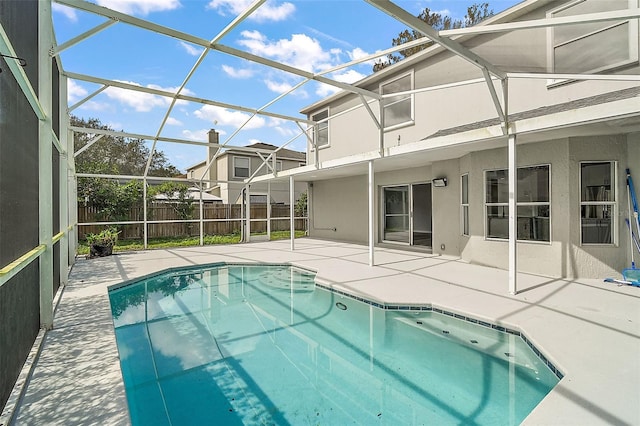 view of pool with glass enclosure and a patio