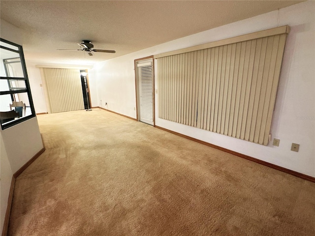 unfurnished room featuring ceiling fan, carpet floors, and a textured ceiling